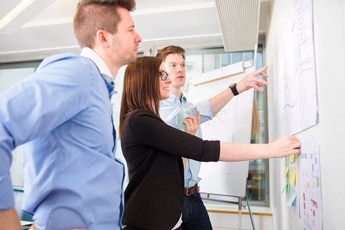 Business People Discussing Over Line Graph Stuck On Wall
