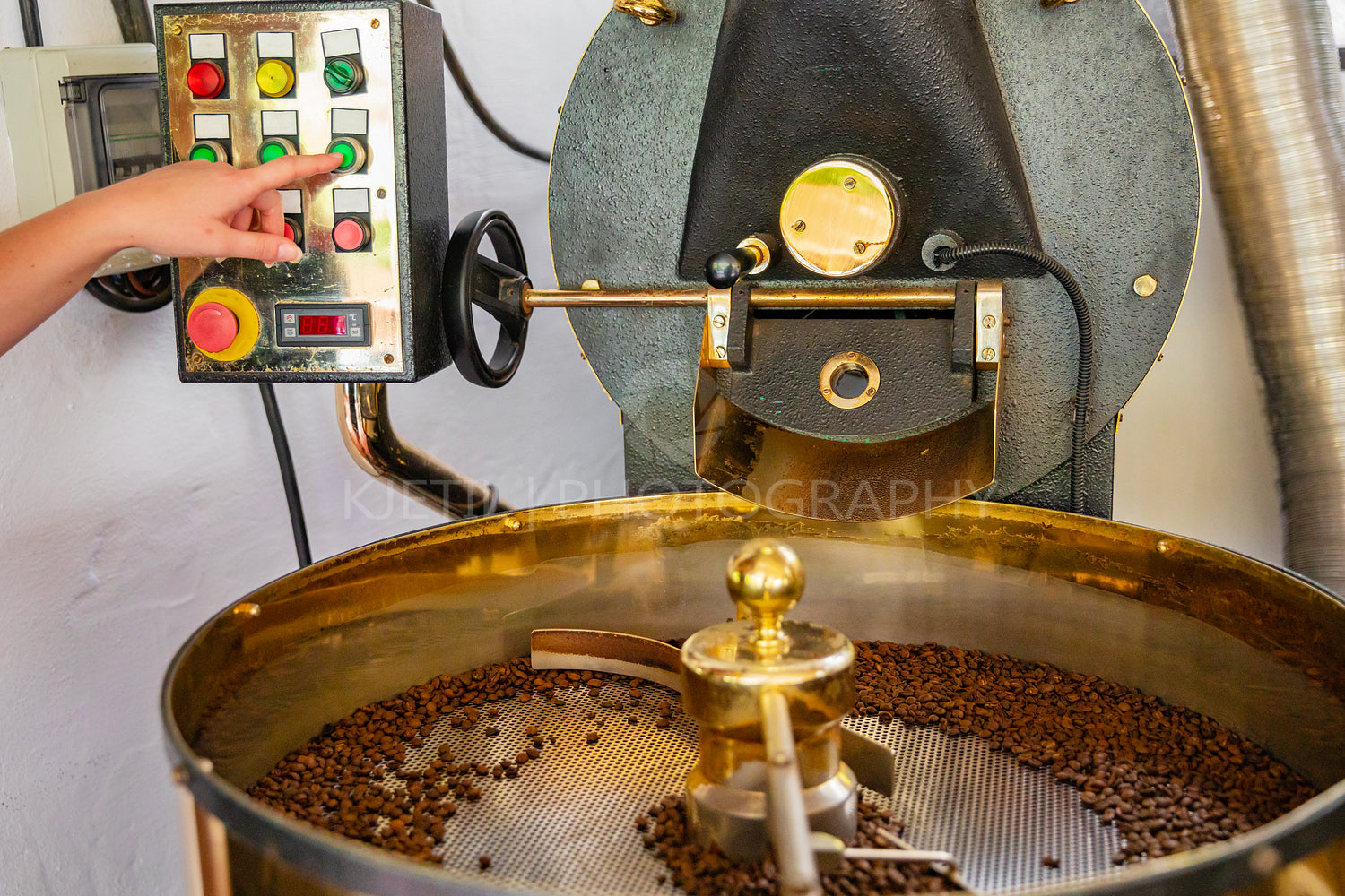 Female Employee Pressing Machinery Button on Coffee Roaster