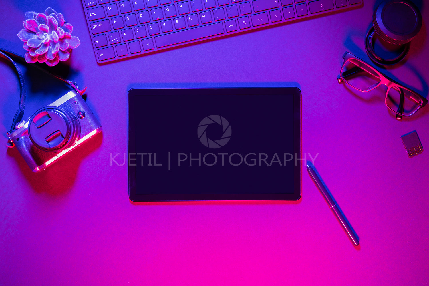 Directly above shot of computer keyboard with camera and digital tablet on illuminated table