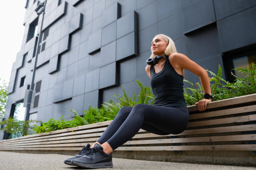 Focused Woman Doing Triceps Dips Outdoor in the City