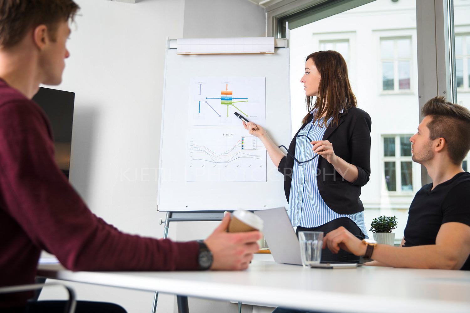 Female Professional Explaining Graph To Male Colleagues