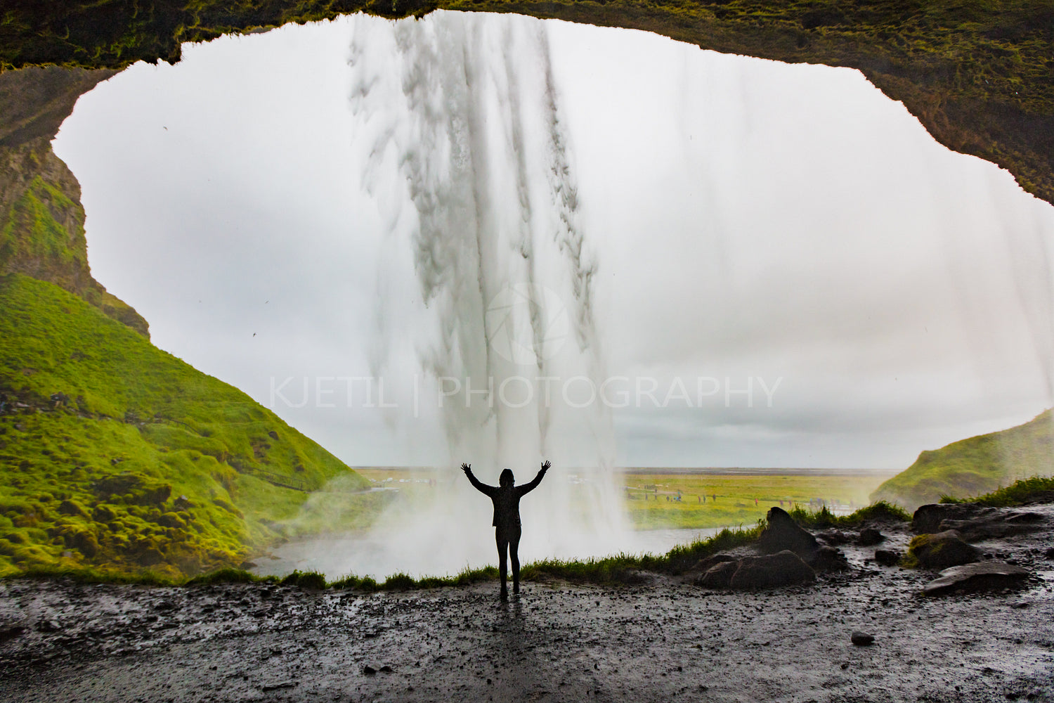 Woman With Arms Raised Standing In Front Of Seljalandsfoss