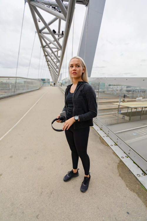 Beautiful Fitness Woman Runner Standing on Modern Bridge In City
