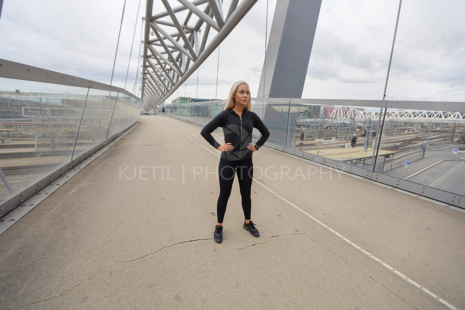 Beautiful Woman Athlete Standing At Modern Bridge In City