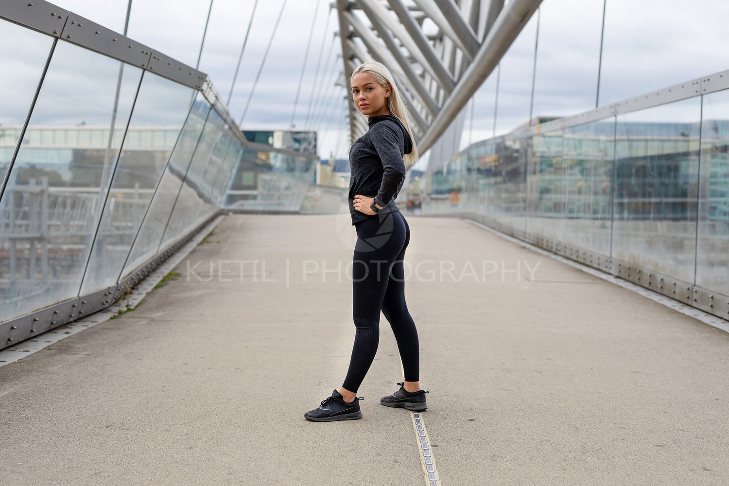 Fit Female Beauty in Black Workout Wear Standing At Modern Bridge In City