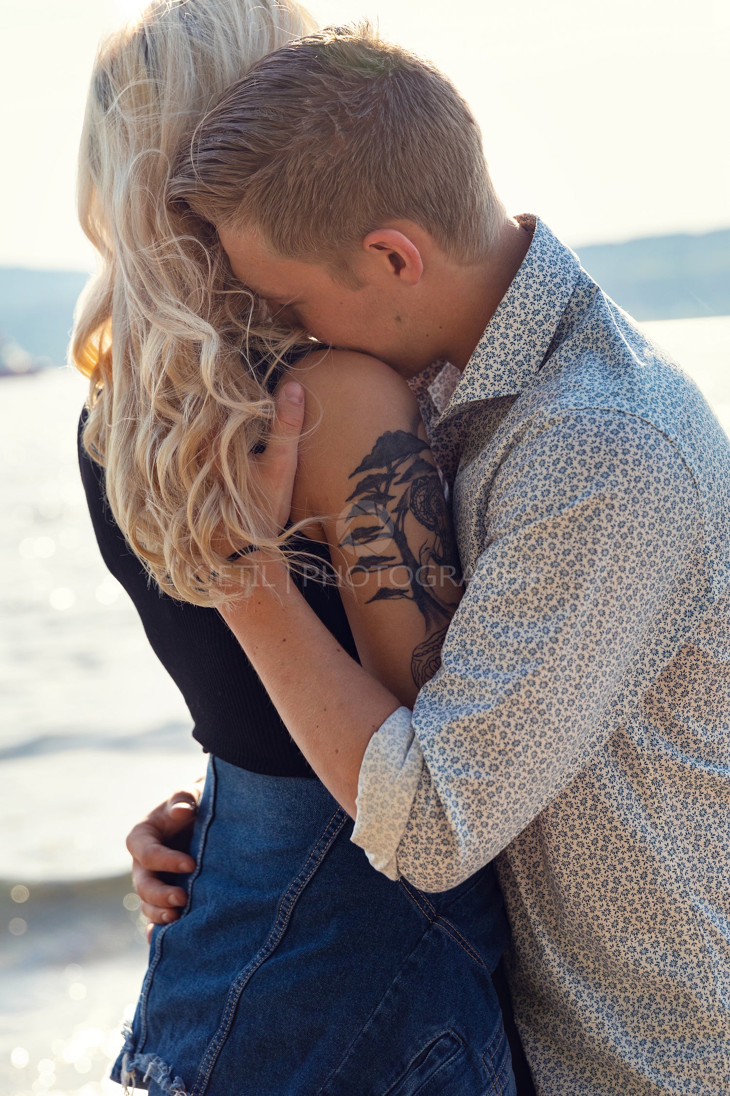 Young Man Embracing Emotional Girlfriend At Beach
