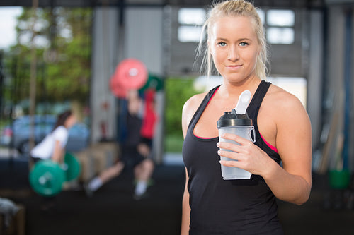 Woman rest and drinking water at fitness gym