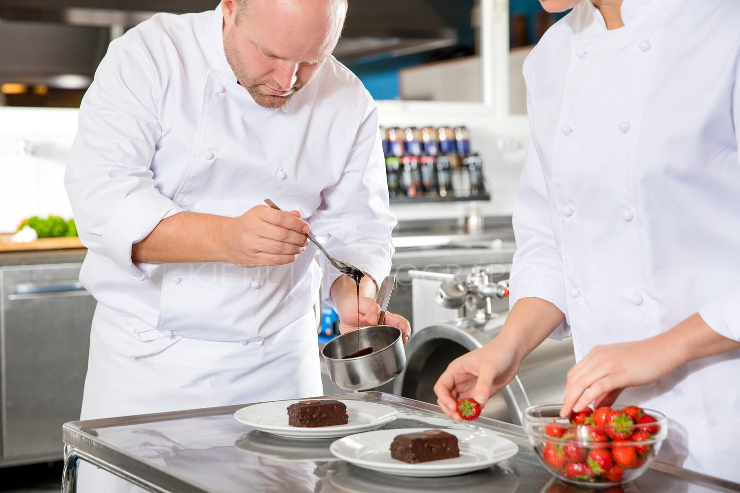 Chef decorates dessert cake with chocolate sauce in kitchen