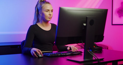 Focused Professional E-sport Gamer Girl Playing Online Video Game on PC