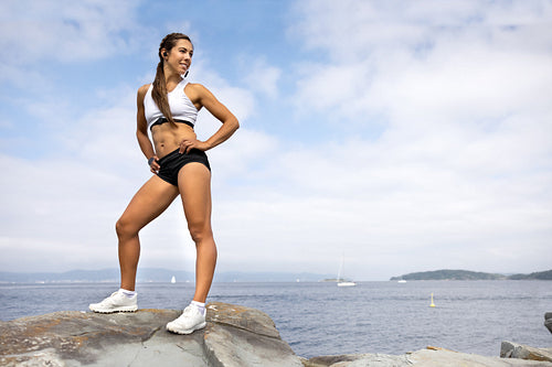 Athletic Woman Looking Away While Standing On Rock