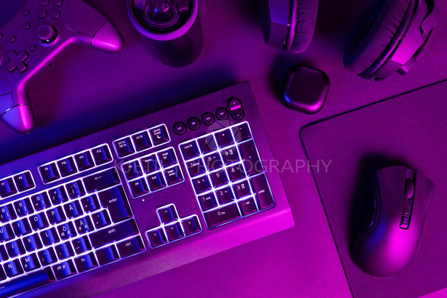 White lit keyboard surrounded by various modern wireless gadgets