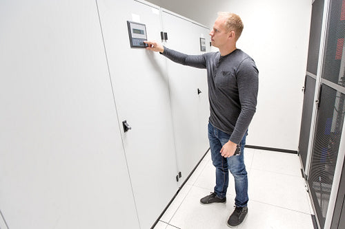 IT engineer adjusts air conditioner in datacenter