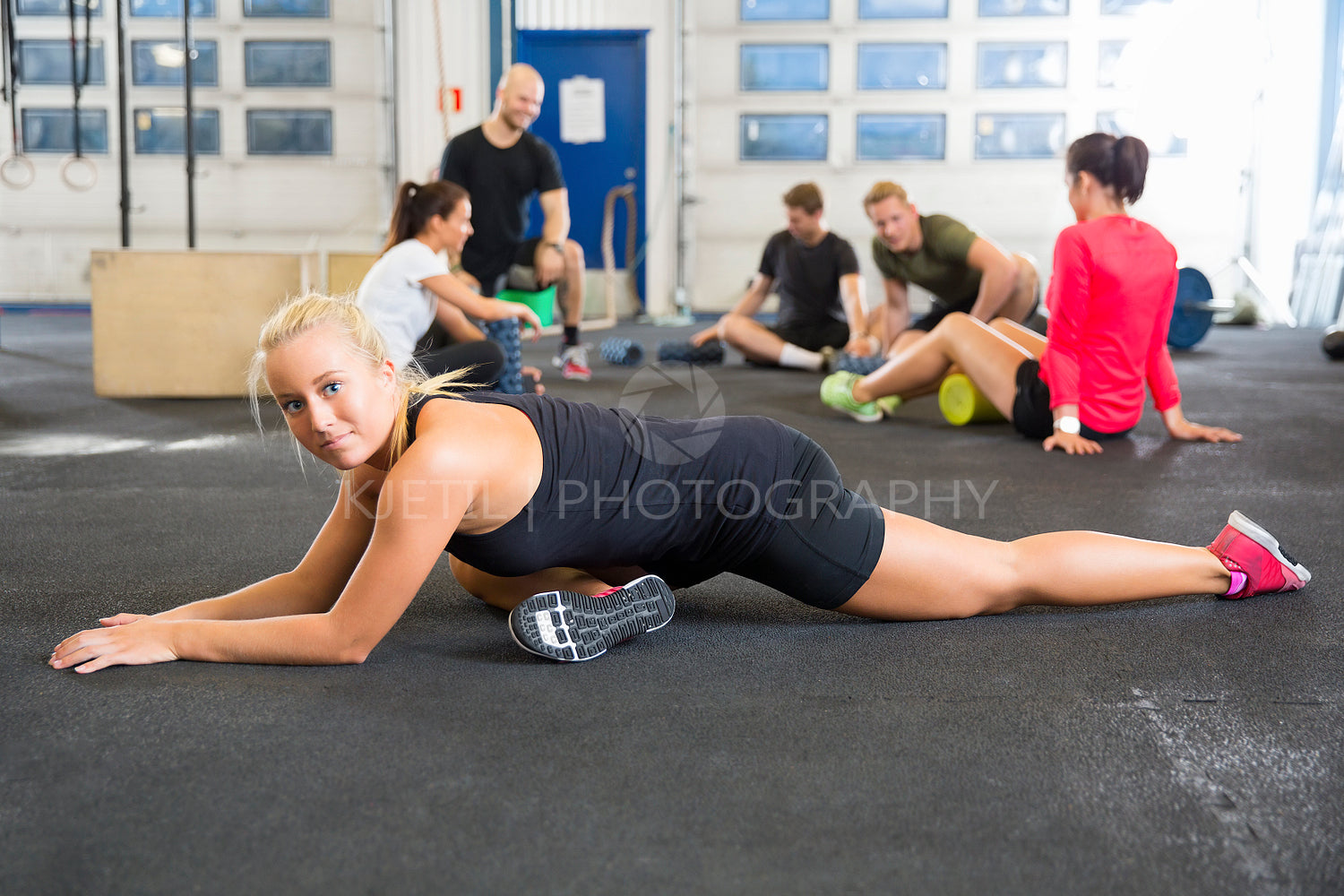 Determined Female Athlete Doing Stretching Exercise At Health Club