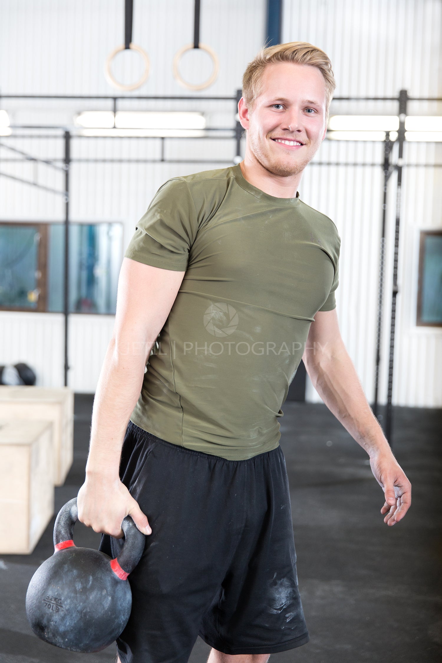Well trained man with kettlebell at fitness gym