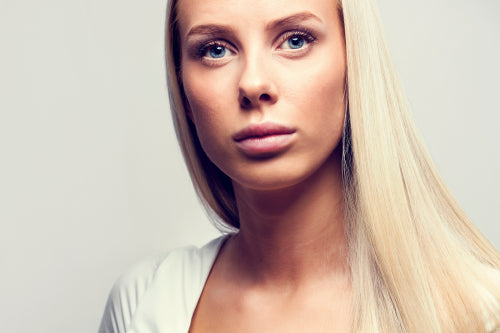 Close-up portrait of a casual blonde woman in white top