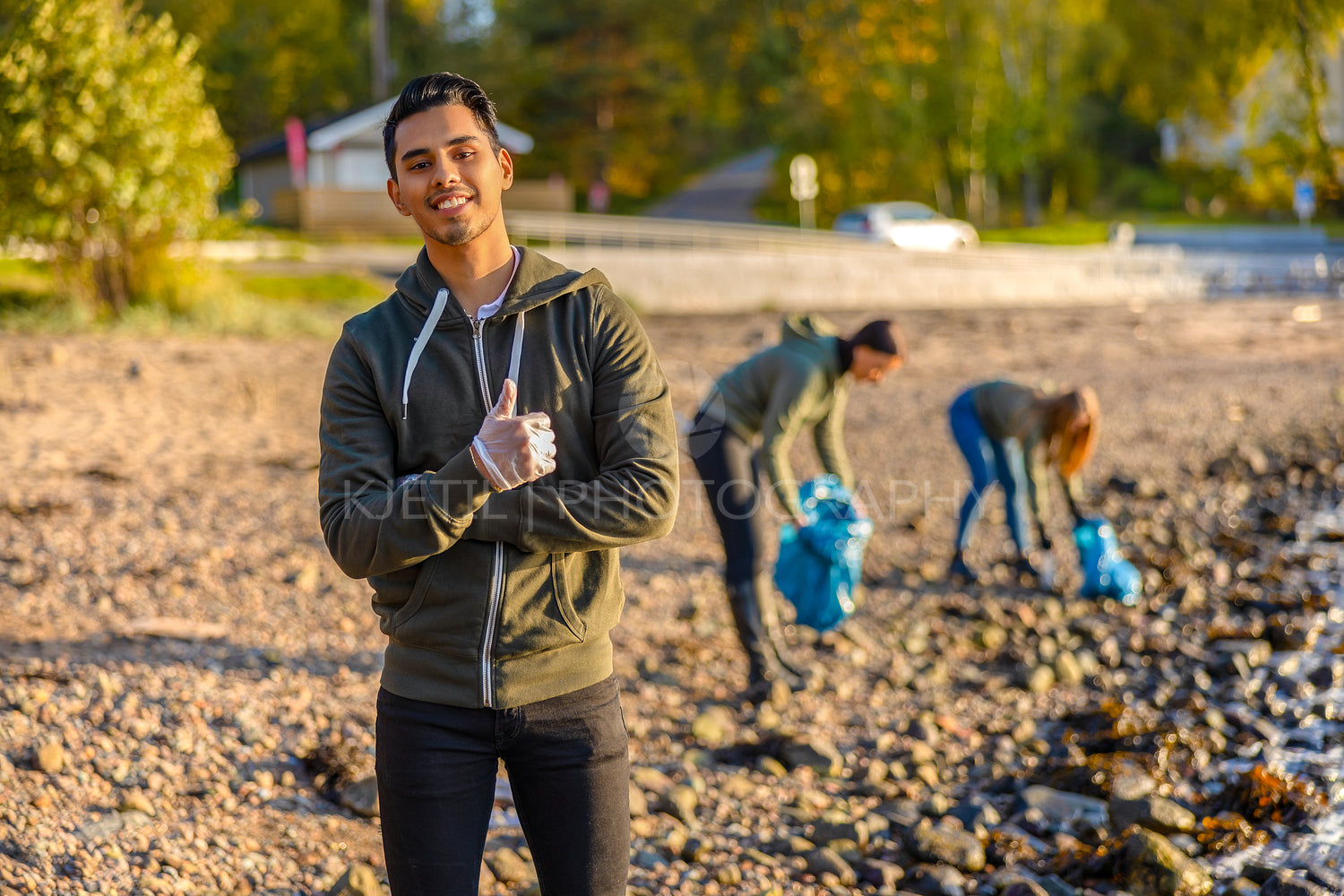 Man showing thumbs up with volunteers at beach