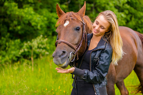 Smiling woman and her happy arabian horse friend in the nature