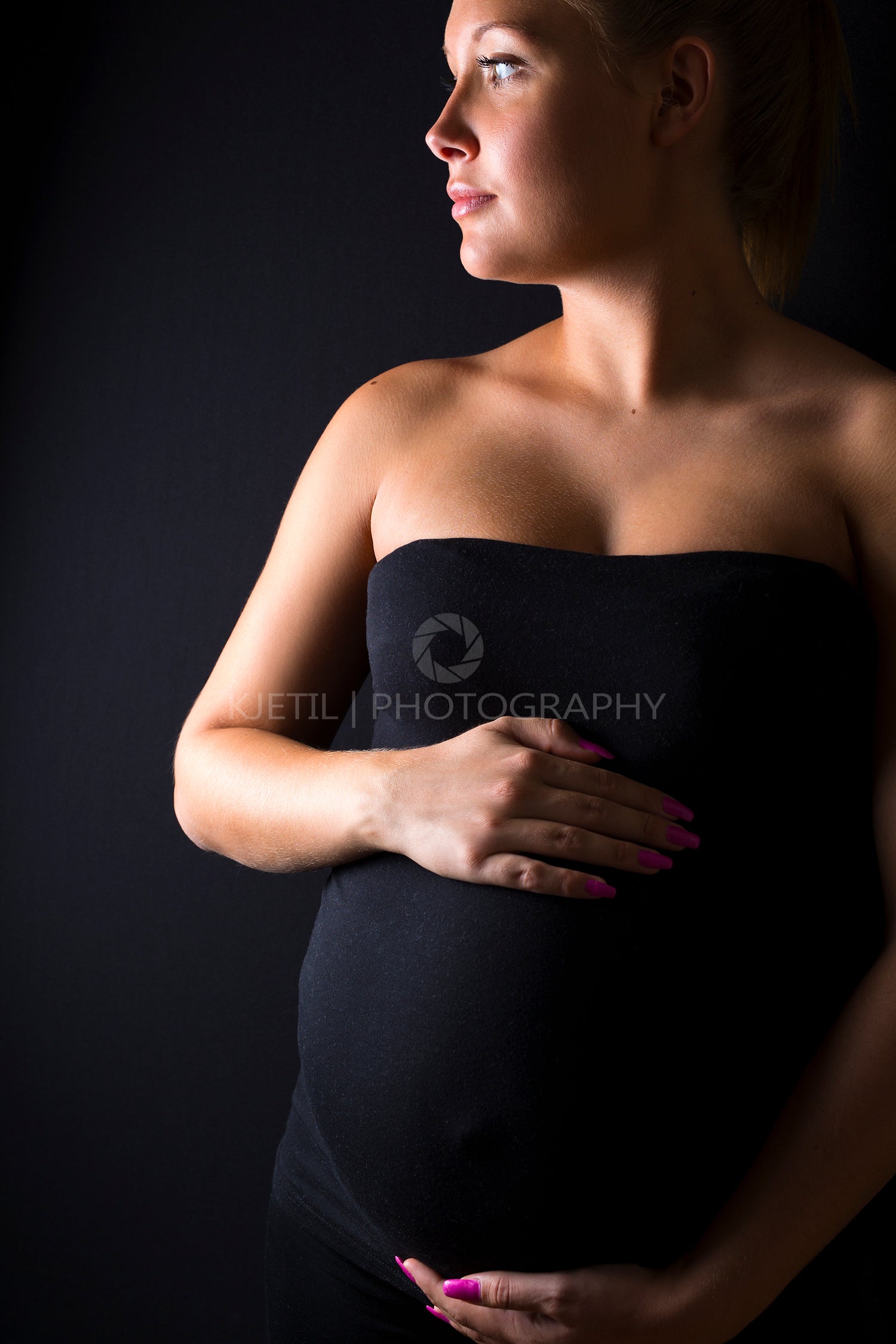 Beautiful pregnant woman stand with hands at the belly