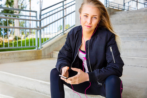 Young Woman In Sportswear Listening Music On Smartphone