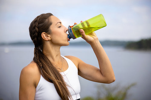 Female Athlete Drinking Water During Outdoor Workout