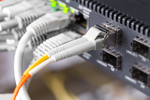 Close-up of high speed fiber network switch and cables in datacenter