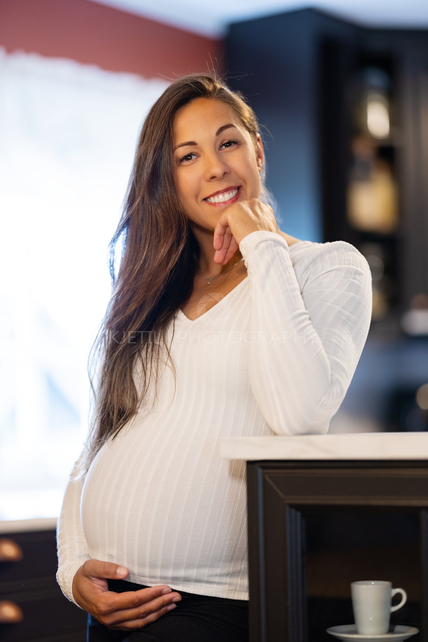 Smiling Pregnant Woman Touching Her Pregnant Belly in the Kitchen