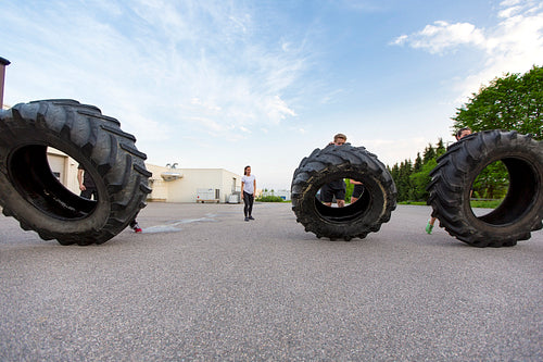 Workout team flipping heavy tires outdoor