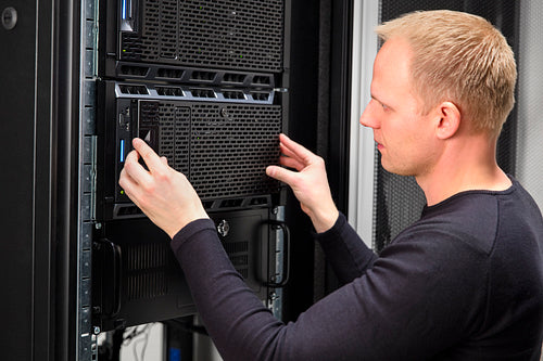 It consultant working with rack server in datacenter