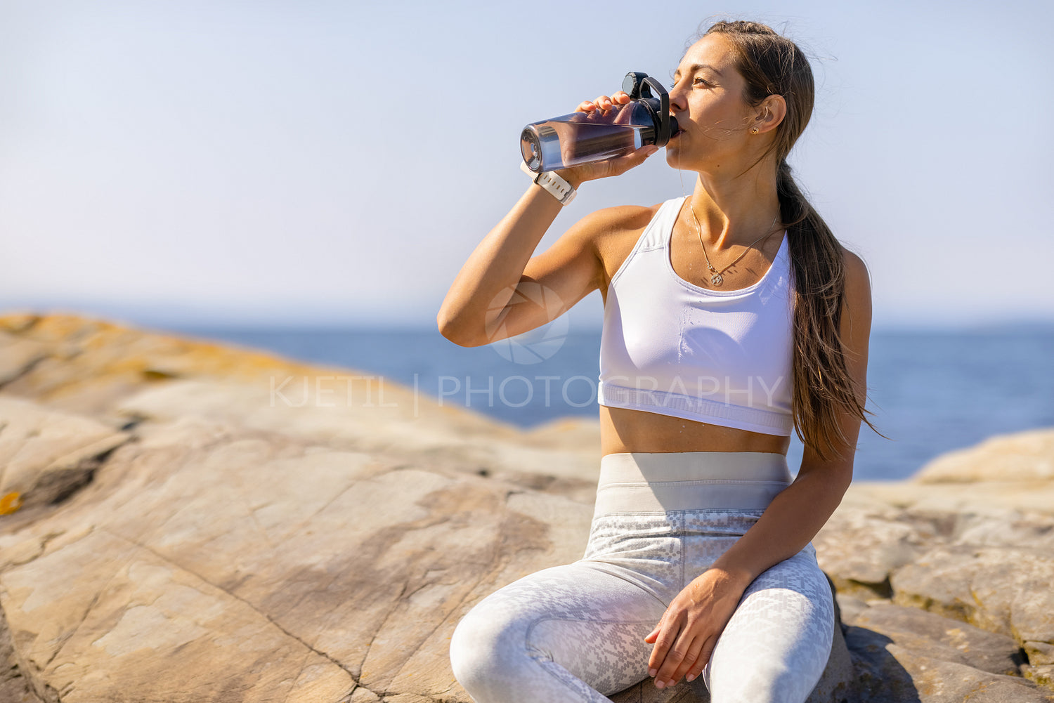Female Athlete Drinking Water During Outdoor Workout by the Sea