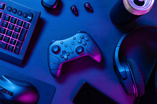 Controller with purple lit keyboard amidst various wireless devices