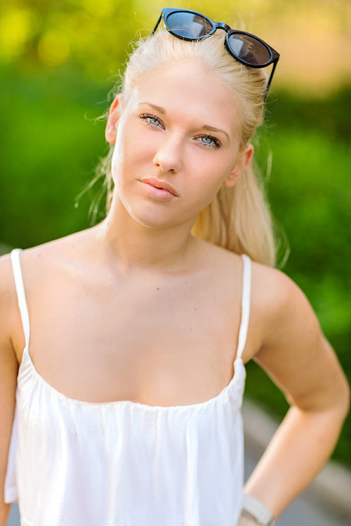 Natural blonde teen girl standing in the street in the sun