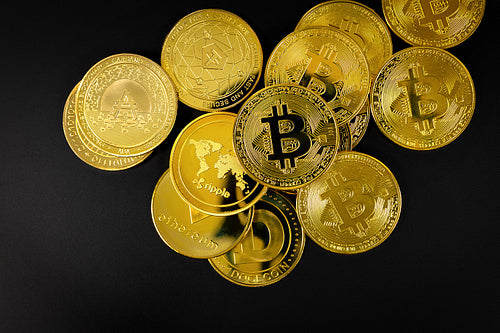 Bitcoin and other Crypto Currency Coins Lying On a Black Background