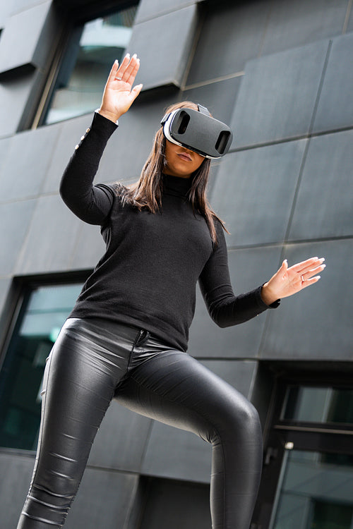 Focused Young Woman Gesturing With Virtual Reality Glasses In Futuristic City