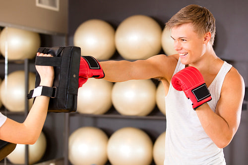 Smiling man training boxing at the fitness gym