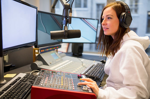 Female Host Using Control Panel At Radio Station