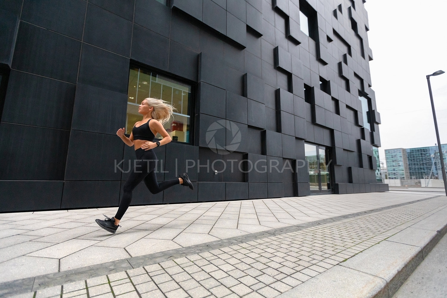 Fast running woman wearing sports top in modern city environment