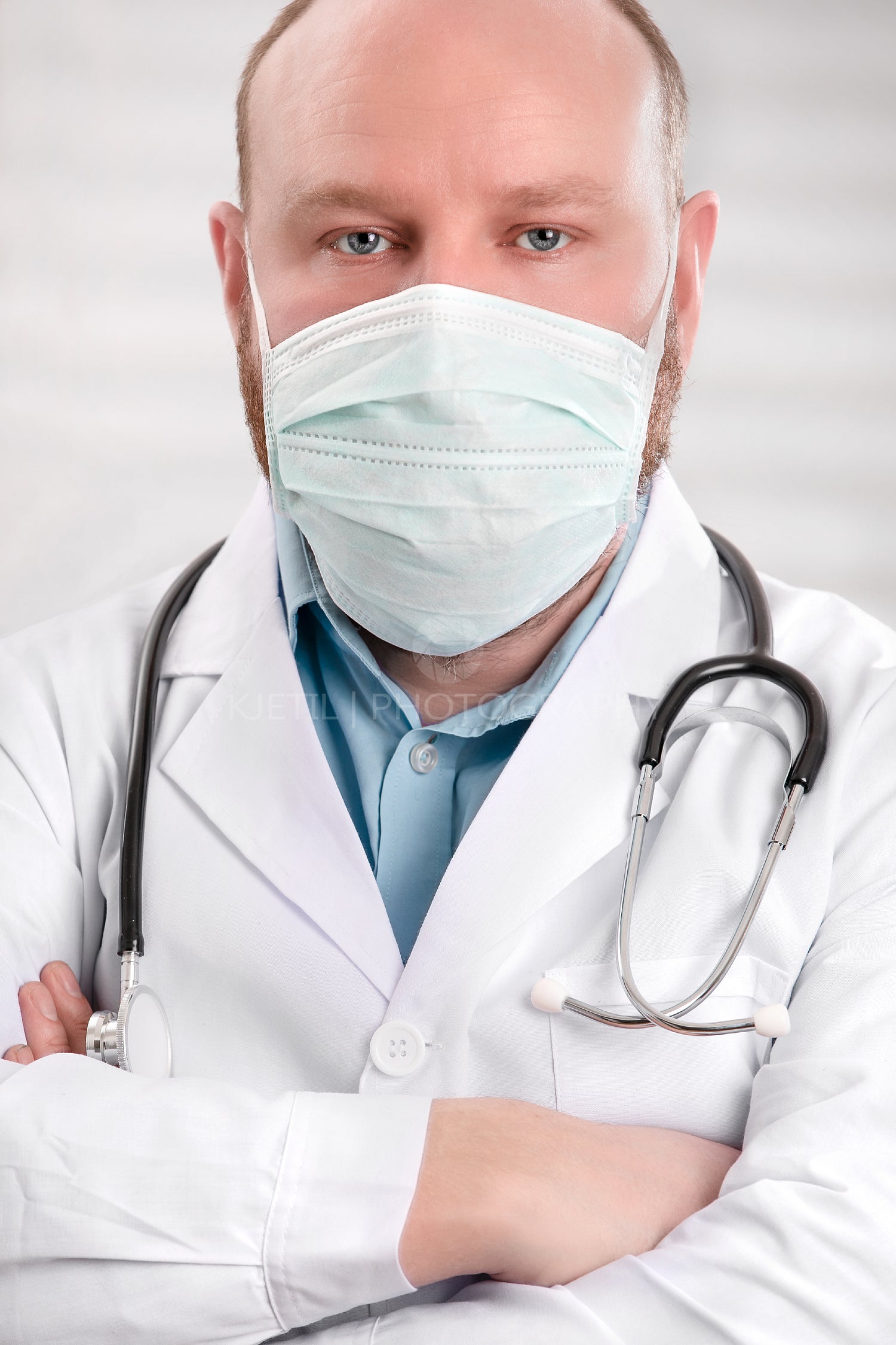 Portrait of a serious doctor wearing protective face mask and stethoscope