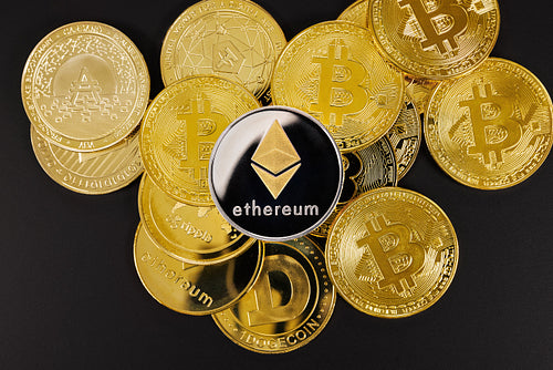 Close-up of ethereum coin on top of various cryptocurrencies
