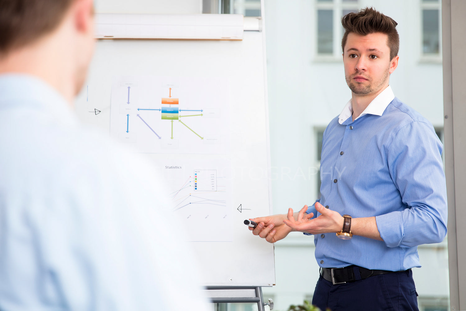 Executive Explaining Presentation To Colleague In Office