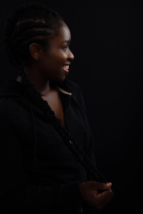 Natural woman with dark skin laughing and wearing black hoodie