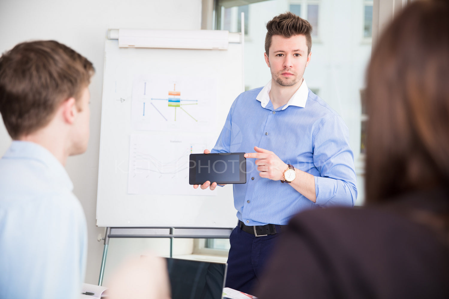 Businessman Showing Tablet Computer To Colleagues