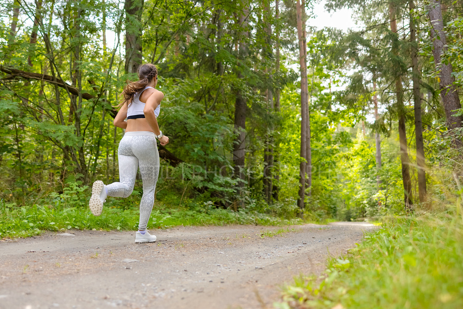 Woman Running In Woodland During Outdoor Workout