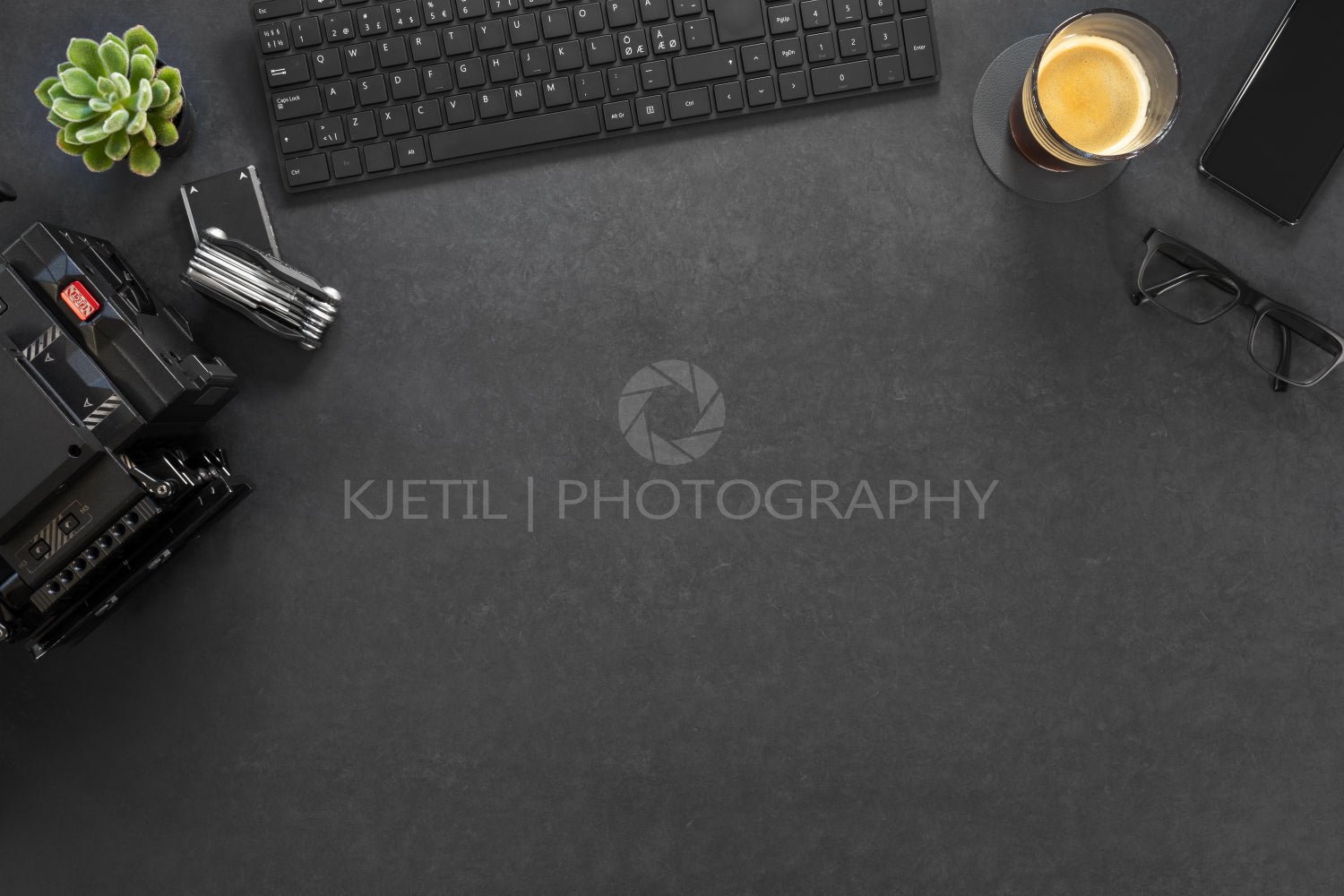 Directly above shot of computer and photographic equipment with coffee on table