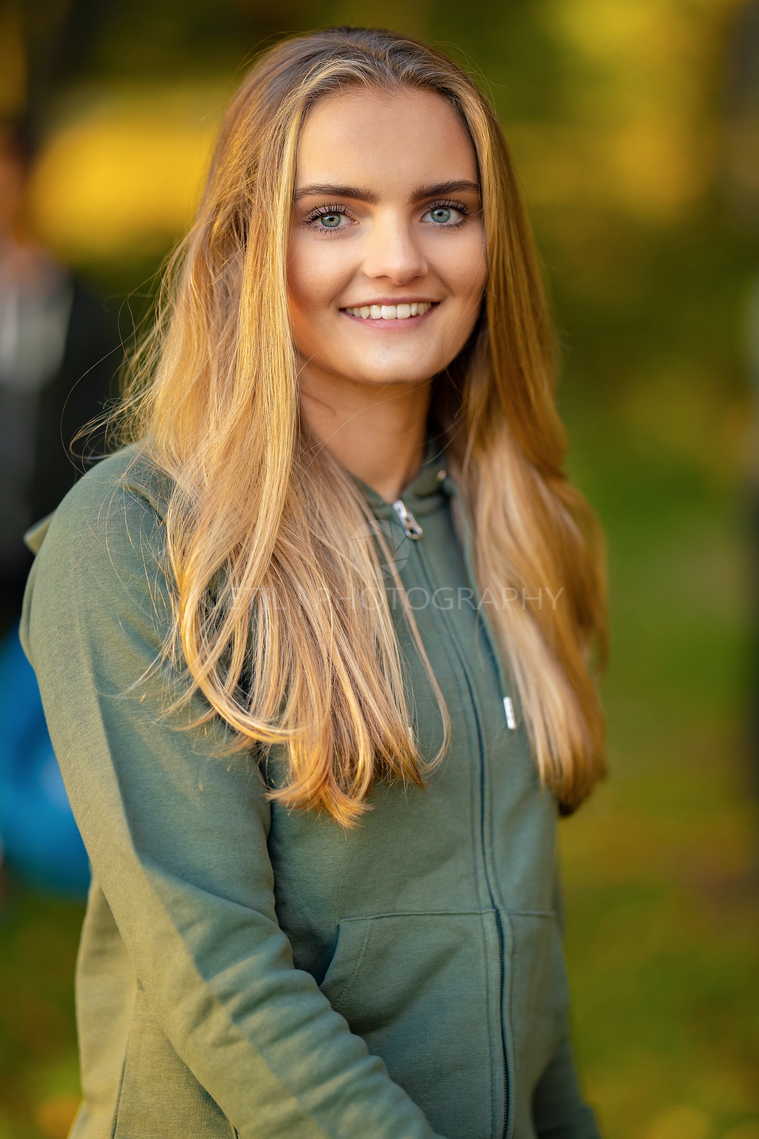 Confident young blond woman standing at park