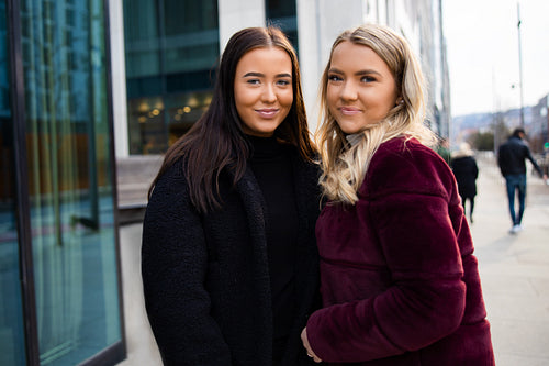 Portrait Of Two Smiling Beautiful Female Friends In City