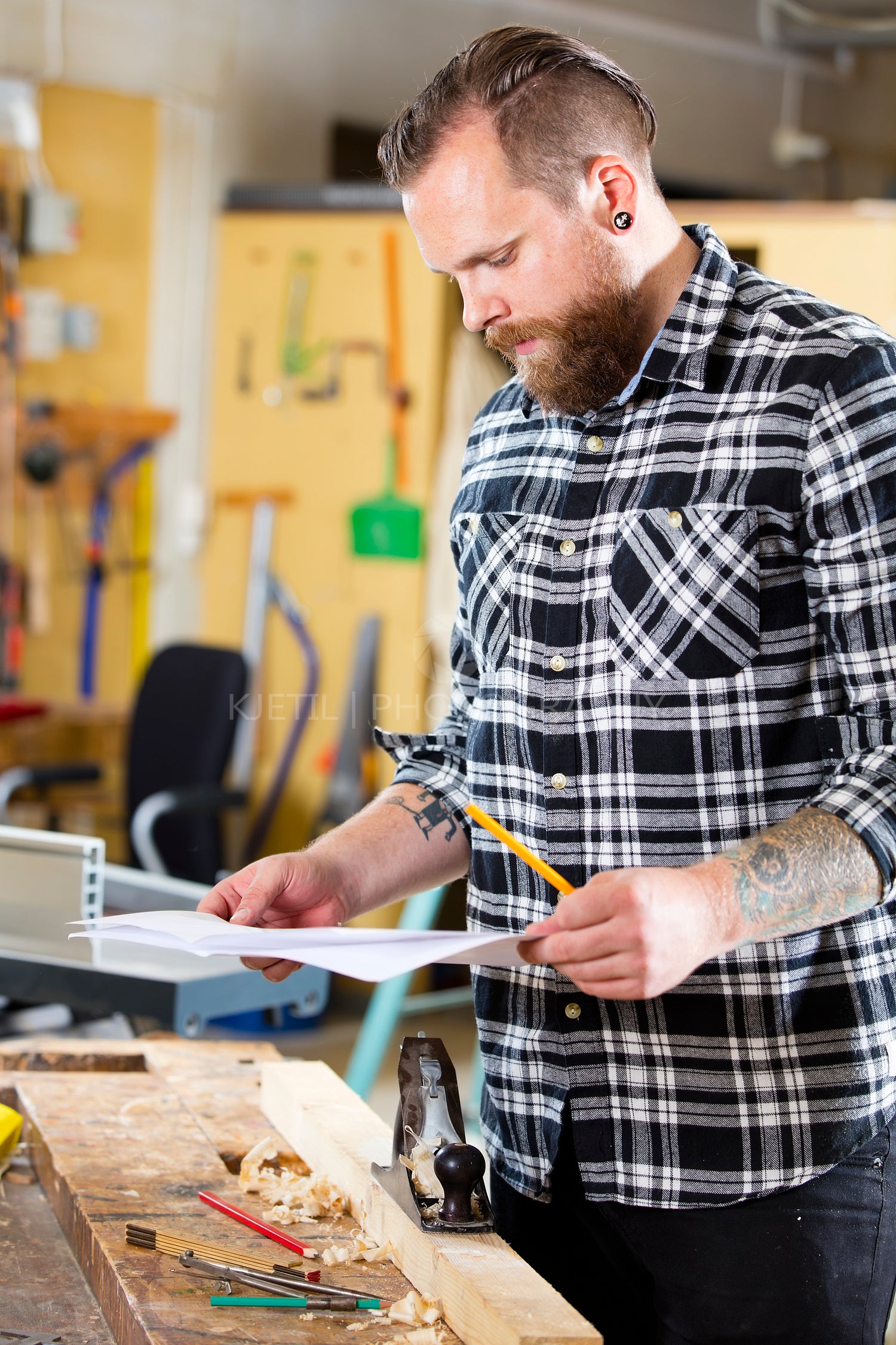 Carpenter planning work and looking at drawings in the workshop