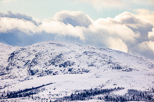 Snow covered mountain and sky with clouds in Norway