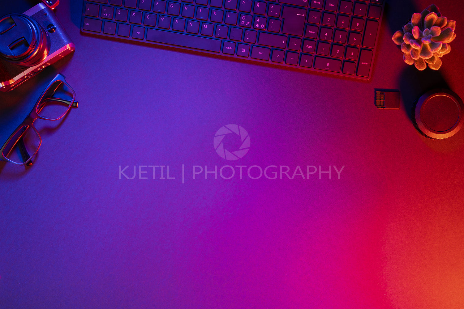 Overhead view of computer keyboard with camera on illuminated table