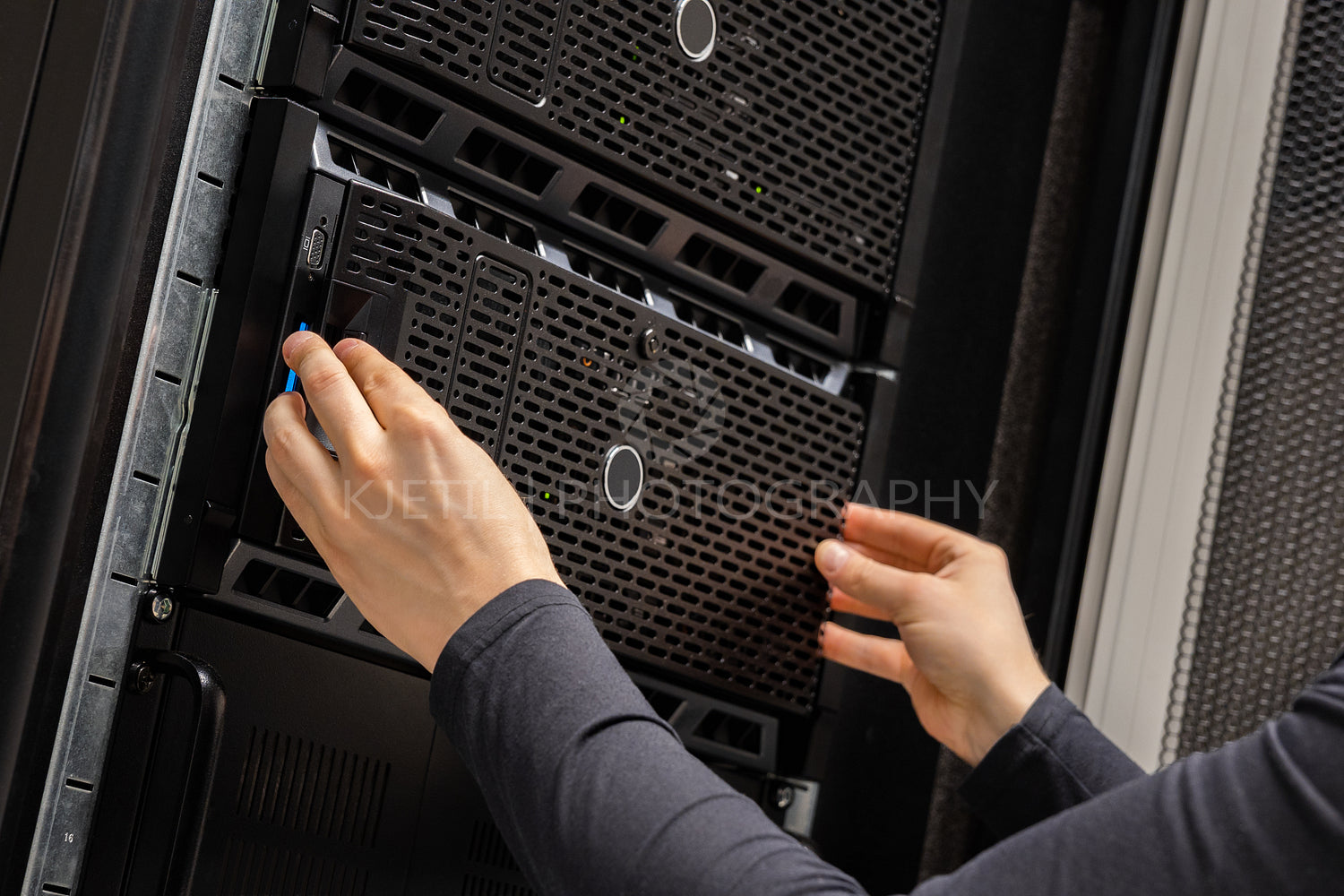 Close-up of Hands Of IT Consultant Installing Servers In Rack at Datacenter