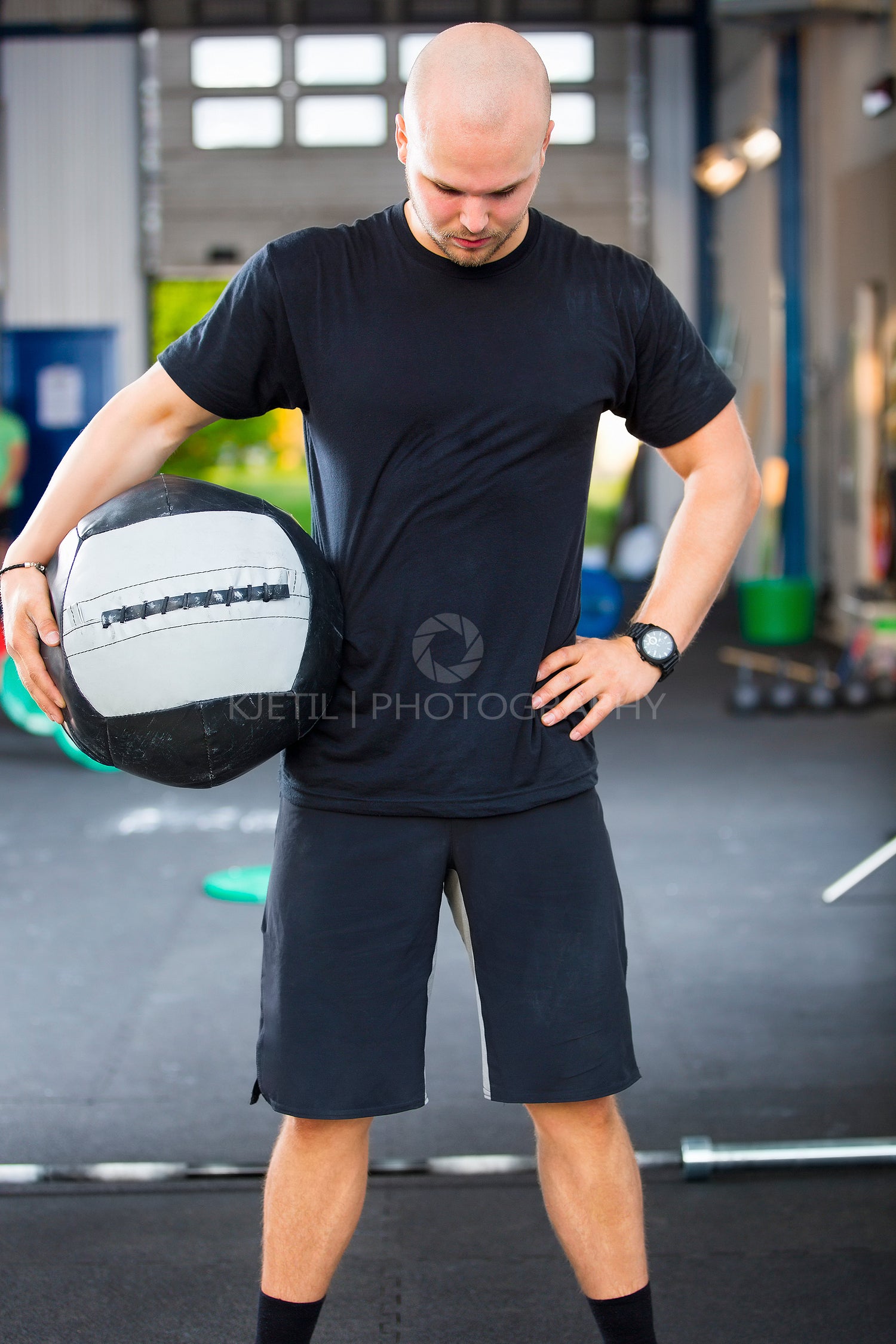 Strong Male Athlete Holding Medicine Ball In Health Club